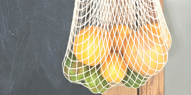 Citrus fruits in a cotton grocery bag hanging